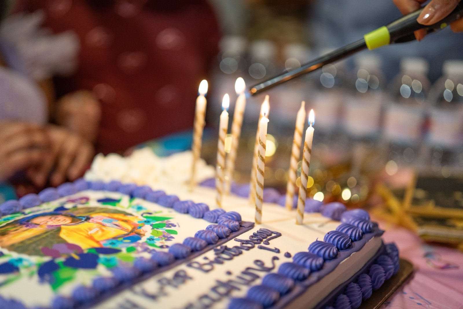 Candles being lit on a birthday cake